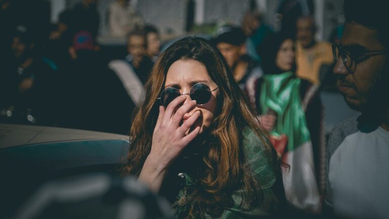 Woman covering her mouth with her hand in a crowd