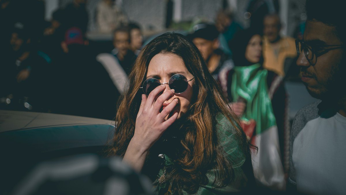 Woman covering her mouth with her hand in a crowd