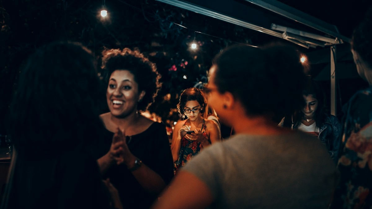 Two friends laughing together outside on a night out