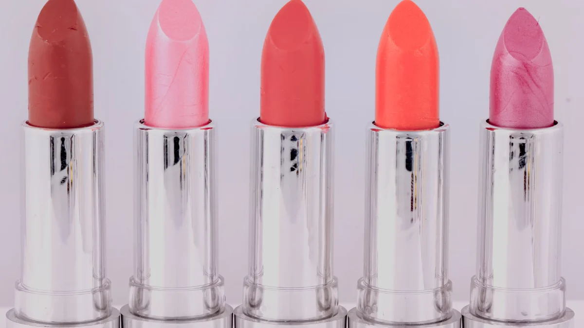 A row of five lipsticks in shades of pink and coral