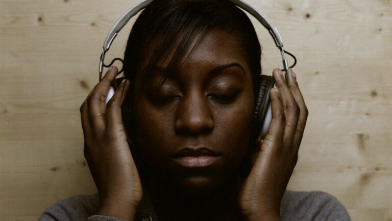 Woman wearing headphones with her eyes closed, lost in music