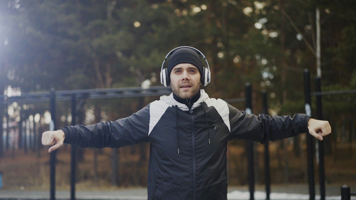 A man wearing headphones stretching before a workout