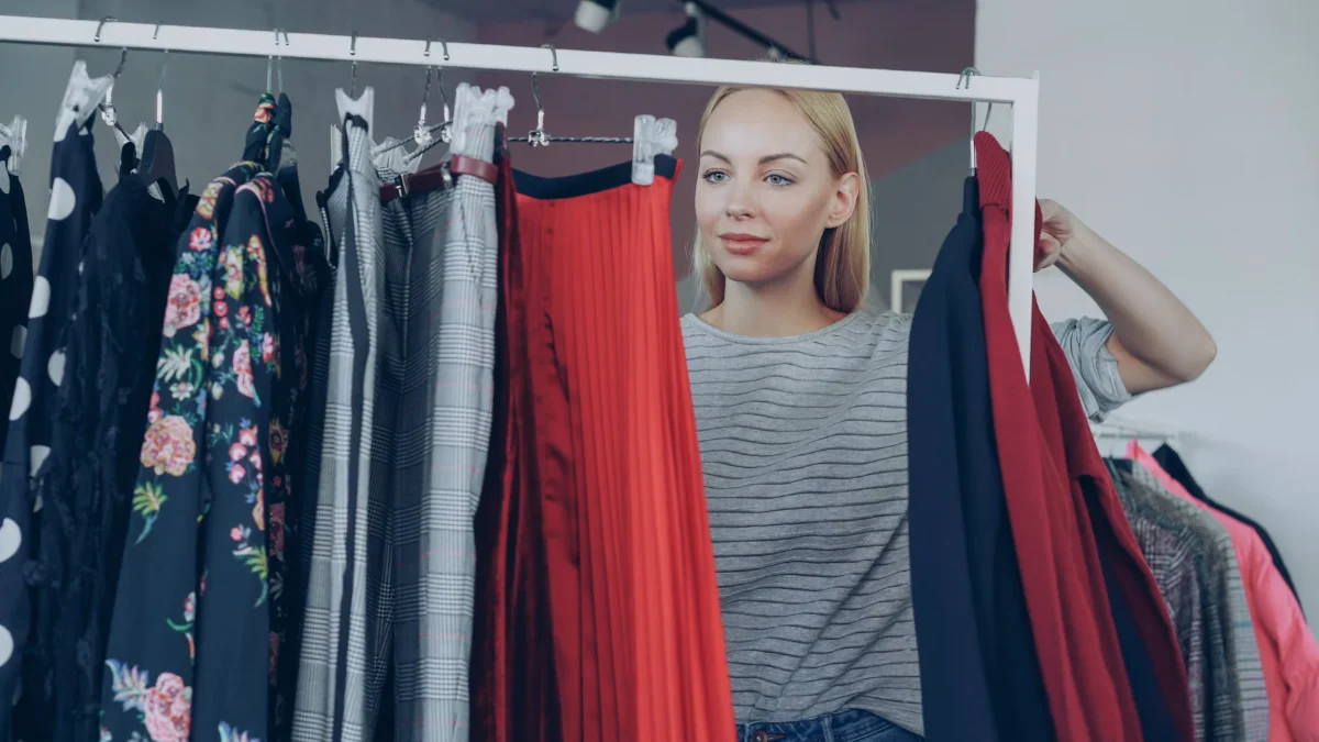A woman browsing a clothing rail in a shop