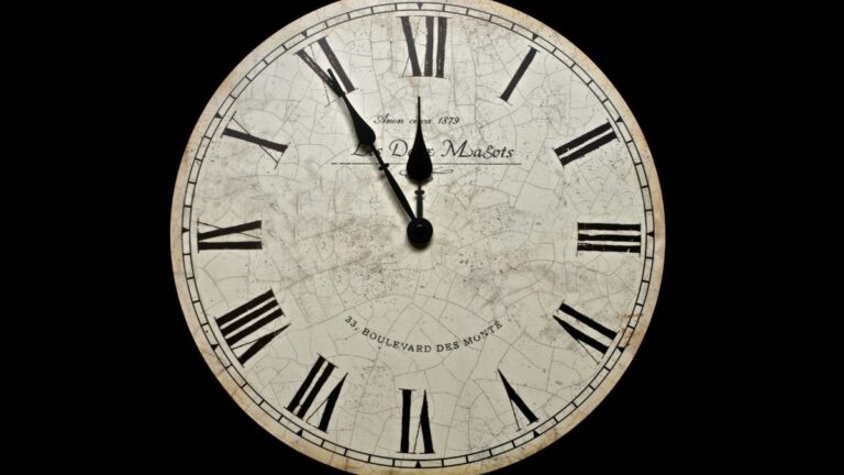 A round clock with Roman numerals against a dark background